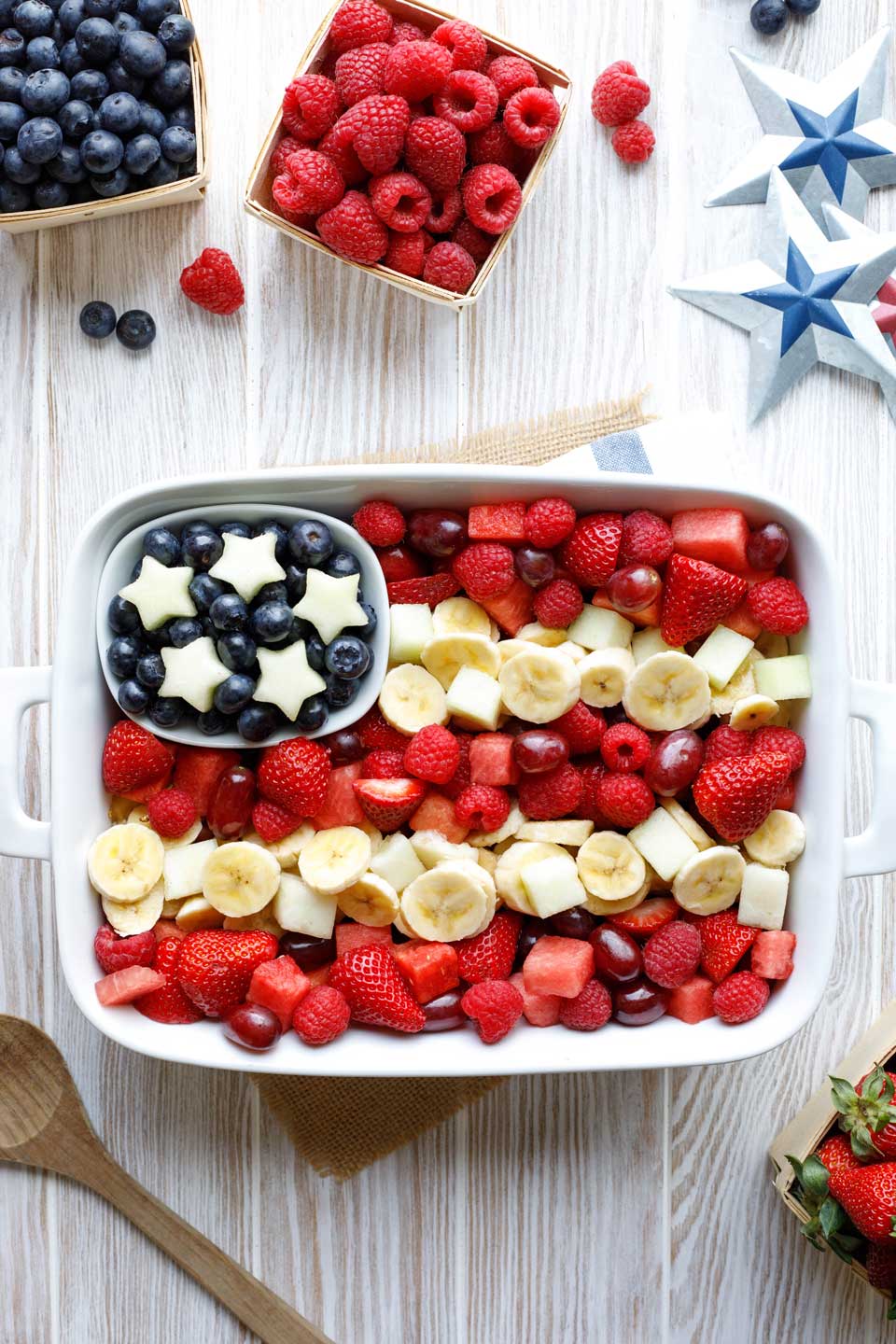 overhead of fruit salad arranged in a white dish to look like an American flag